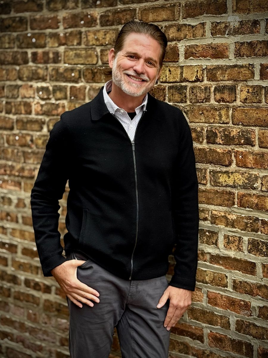 Billy Hyland, founder of Level Positive, smiling against a brick wall